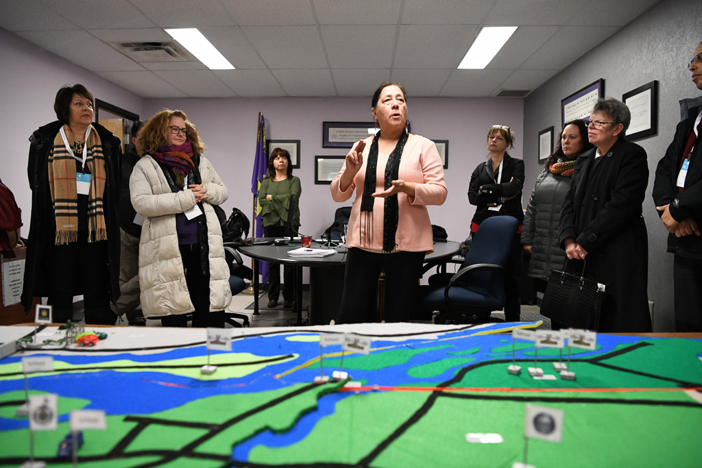 Woman stands in front of maquette of Mohawk Nation of Akwesasne