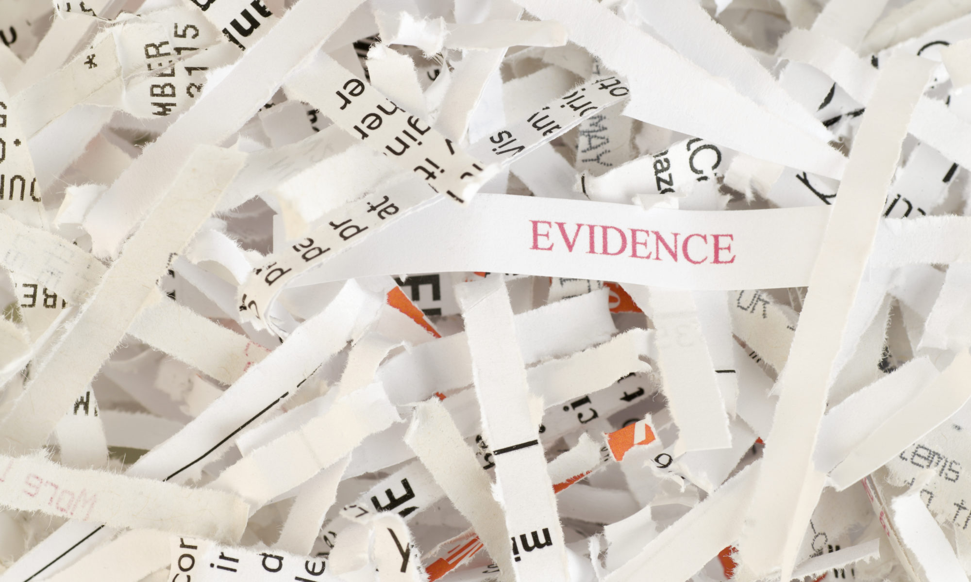 Shredded paper with the word EVIDENCE written on one of the pieces of paper demonstrating evidence destruction and possible obstruction of justice