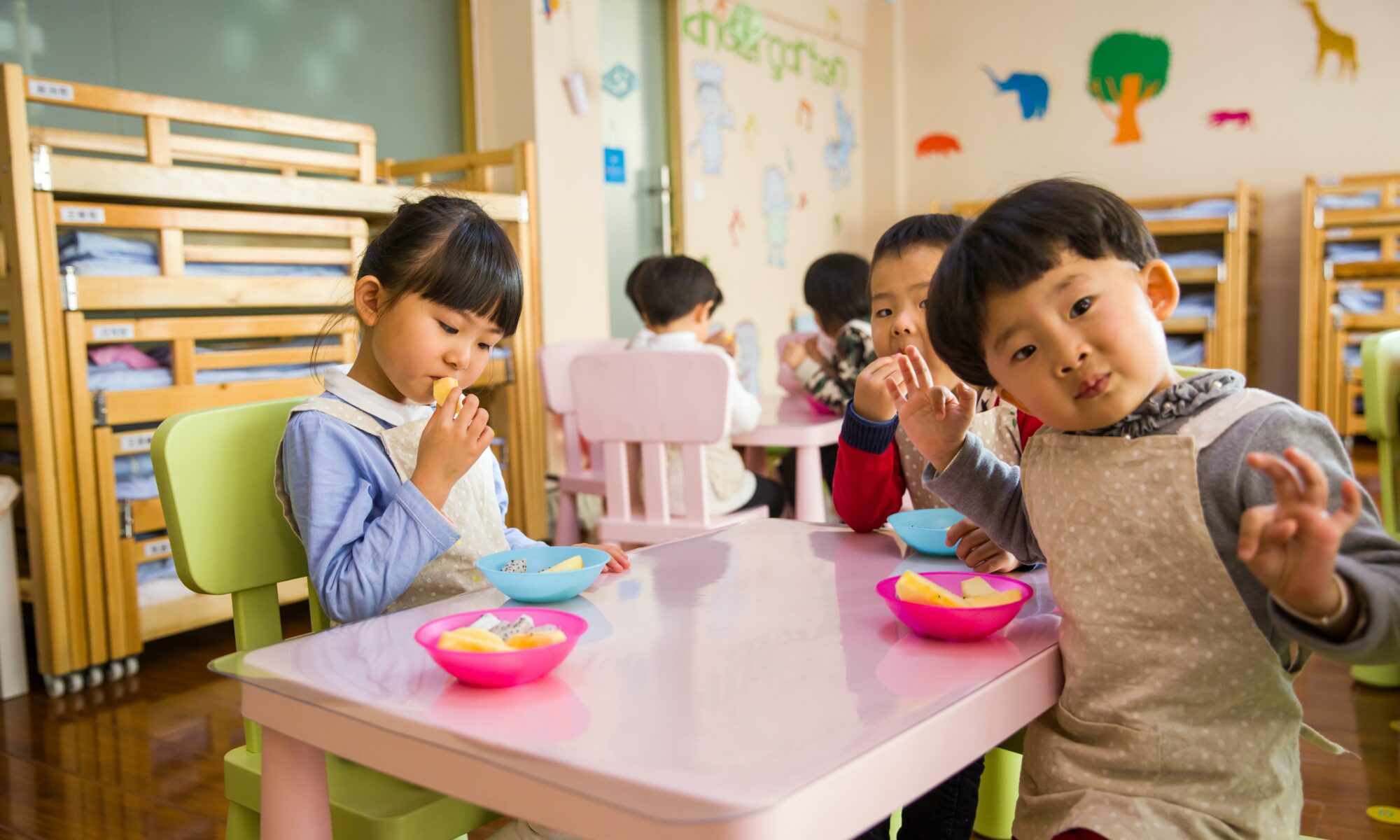 children sitting together at a table in a childcare facility